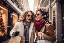 Two Cheerful Female Friends Holding Shopping Bags On Snowy Winter Day. Women Making Shopping During Christmas Sales Season.