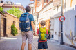 © galitskaya - Happy father and son tourists on background of old street of Antalya. Traveling with kids concept. male tourist traveler discover interesting places and popular attractions and walks in the old city