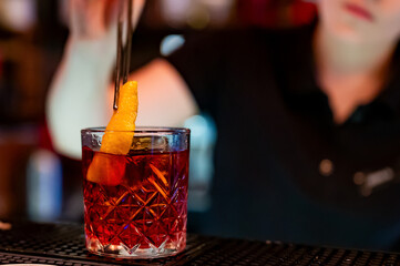 Wall Mural - woman hand bartender making negroni cocktail in bar