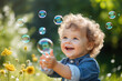 © AI_images - Beautiful little child toddler boy having fun with blowing soap bubble blower.