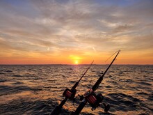 Fishing Poles With Sunrise Glowing Over Lake Michigan Horizon