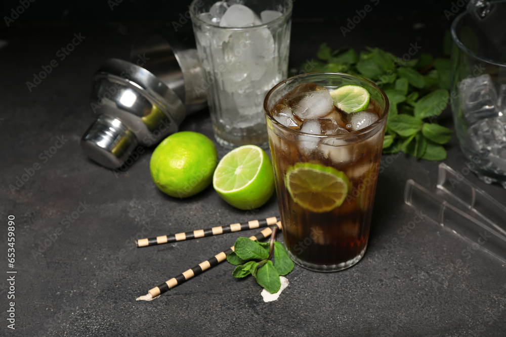 Glass of cold Cuba Libre cocktail on dark background