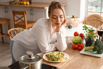 Canvas Print - Young woman with tasty pasta in kitchen