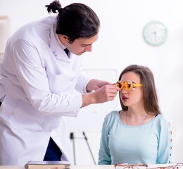 Wall Mural - Young woman visiting male doctor oculist