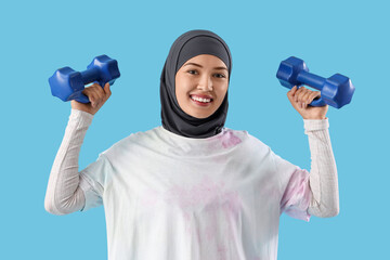 Sticker - Sporty Muslim woman with dumbbells on blue background