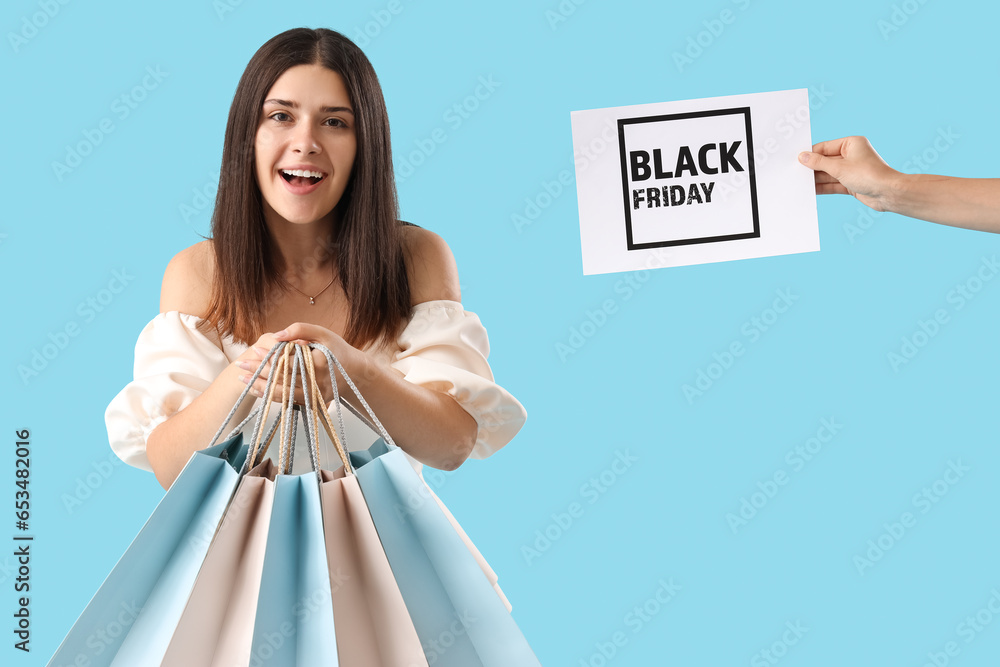 Young woman with shopping bags on blue background. Black Friday sale