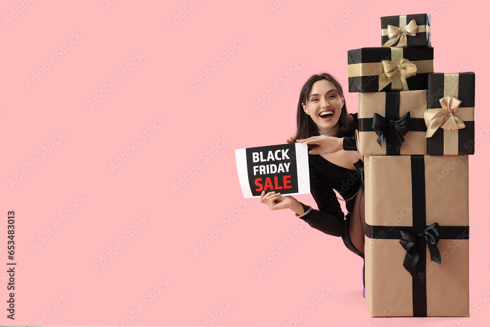 Young woman with gifts on pink background. Black Friday sale