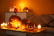 Leinwandbild Motiv Halloween pumpkins with burning candles on table in dark living room
