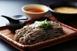 Zaru soba, chilled buckwheat noodles, are served over a bamboo mat, accompanied by a fragrant dipping sauce enriched with soy and mirin, and a variety of toppings such as shredded nori seaweed,