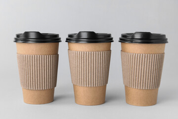 Poster - Paper cups with black lids on light grey background. Coffee to go