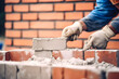 © VIX - bricklayer worker installing brick masonry on exterior wall with trowel putty knife