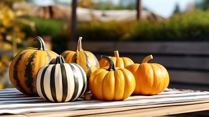 Striped pumpkins served on a wooden table a sunny autumn day. Thanksgiving decoration outdoors and celebration of traditional autumn holidays