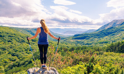 Wall Mural - Hiker woman on peak enjoying panoramic mountain landscape view- Croatie-Krk island