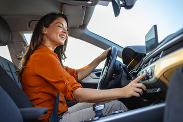 Happy business woman listening to music while traveling with her car around the city.