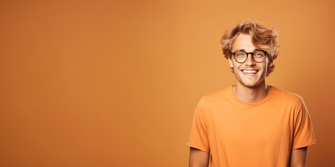 Wall Mural - Handsome blond man wearing orange t-shirt and glasses. Isolated on orange background.