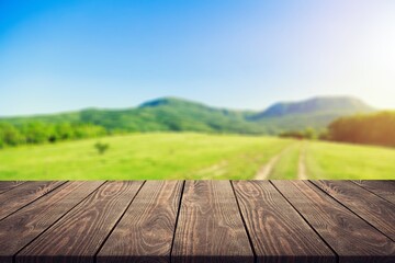 Wall Mural - Wooden table on blur field background