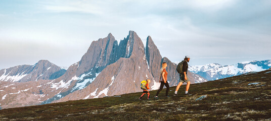 Wall Mural - travel family hiking in mountains outdoor parents father, mother and child together trekking in norw