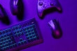 © kjekol - Top view of illuminated gaming gadgets on purple desk