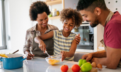 Wall Mural - happy african american family preparing healthy food in kitchen, having fun together on weekend