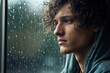 A young man sad of sit on the edge the window with raindrops on the glass window on a rainy day ,Generative AI.