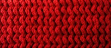 Hand knitted red wool fabric with a pattern texture