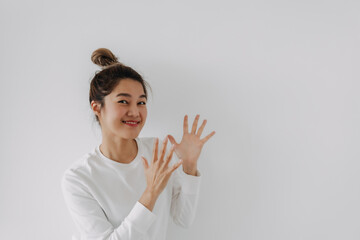 Happy asian Thai woman hair bun clapping and applauding  her hands, happy enjoying and joyful, smiling proud hands together, isolated on white background in winter.
