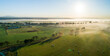 © Austockphoto - Panorama of green farmland in morning light with mist over river
