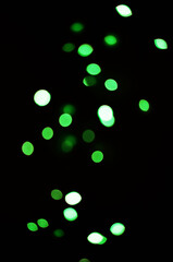 Wall Mural - green light, bokeh and shine on black background isolated on a mockup space. blur, dark backdrop and