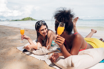 Wall Mural - Happy beauty woman in bikini sitting and drinking together on the beach having fun in a sunny day, Beach summer holiday sea people concept.