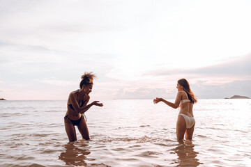 Wall Mural - Happy beauty woman in bikini walking and playing together on the beach having fun in a sunny day, Beach summer holiday sea people concept.