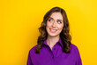 Photo of friendly dreamy satisfied woman with wavy hairstyle dressed purple shirt look at offer empty space isolated on yellow background