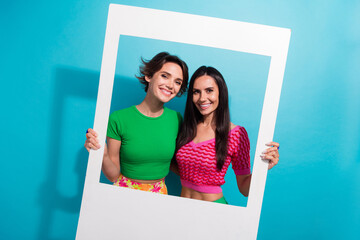 Canvas Print - Photo of shiny cheerful girls dressed colorful outfits tacking photo portrait together isolated blue color background