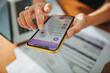 © Marko Geber - Young woman checking her profile on a bank app while paying bills at home