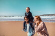© Marko Geber - Young family walking and having fun on the beach