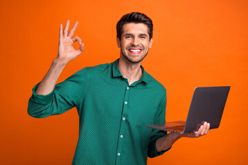 Poster - Photo of funky cool guy wear green shirt showing okey working modern gadget isolated orange color background