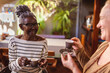 © Nexa - Senhoras idosas alegres tomando cafe juntas.