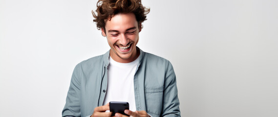 Wall Mural - Happy smiling young man using his phone on a colored background.