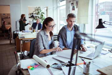 Young man and woman working together on a project in a startup company office