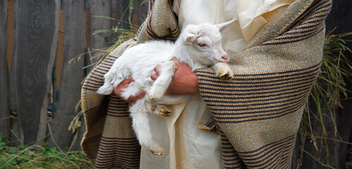 Poster - Shepherd with a sheep in his arms