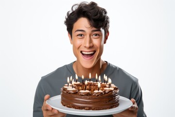 Poster - A young man is holding a chocolate cake with lit candles. This image can be used for birthday celebrations or special occasions.