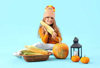 Wall Mural - Cute little girl with lantern and vegetables on blue background. Thanksgiving Day celebration