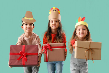 Wall Mural - Cute little children with gifts on green background. Thanksgiving Day celebration