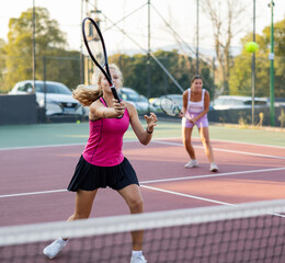 Wall Mural - Woman tennis player training on court. Woman using racket to hit ball.