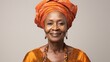 Elderly Afro-American woman wearing an orange head wrap and traditional dress, showcasing African cultural heritage.