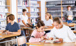 © JackF - Two female friends reading books together and preparing for exams in the school library