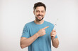 Happy man holding electric toothbrush on white background
