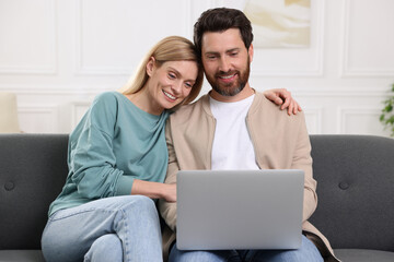 Sticker - Happy couple with laptop on sofa at home