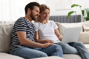 Sticker - Happy couple with laptop on sofa at home