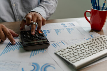 Wall Mural - man using a calculator accountant working on desk budget and loan Close up Accounting analysis, tax finance, bank income savings budget