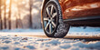 Sunlit view of a car's tire tread imprinted on fresh snow, symbolizing secure journeys in frosty conditions.